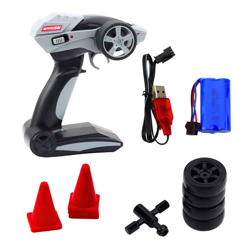 RC drifta mašīnas piederumi: tālvadības pults, četras rezerves riepas, akumulators ar USB lādētāju, atslēga riteņu nomaiņai un četri oranži satiksmes konusi.