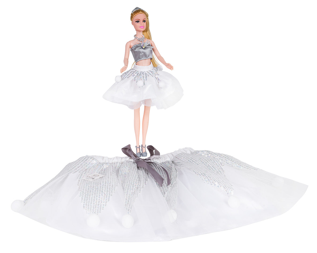 Lelle ar sudraba topiņu un baltu svārku komplektu, blakus novietoti identiski bērnu svārki ar spīguļiem un banti