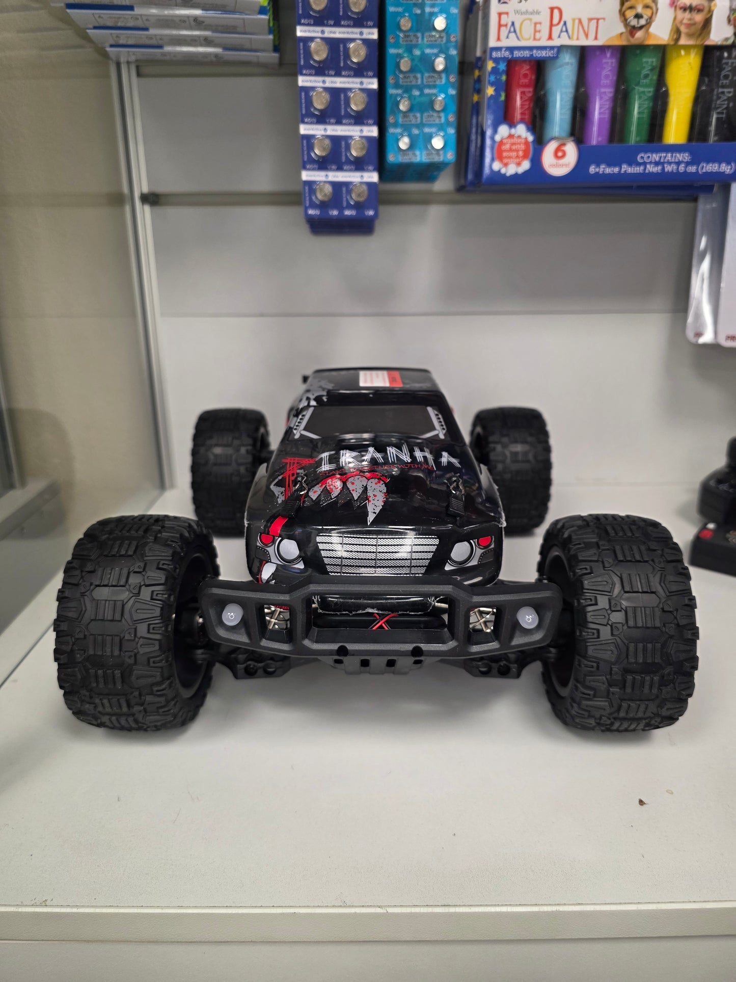 “RC mašīna Titan-X skatā no priekšas ar lieliem bezceļa riepu protektoriem.