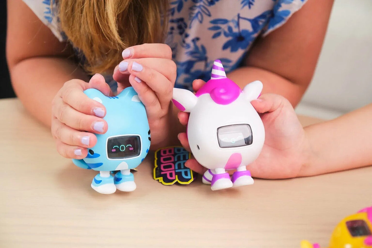 Bērns rokās tur Beep Boop interaktīvās rotaļlietas – kaķa un vienradža figūriņas ar ekrāniem