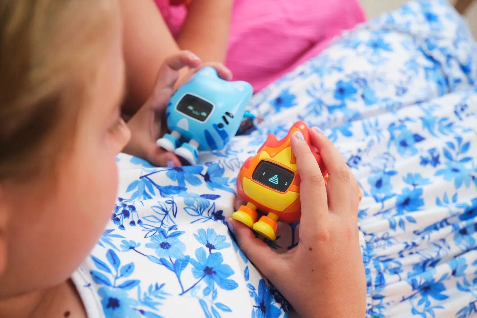 Bērns spēlējas ar interaktīvajām Beep Boop rotaļlietām ar ekrāniem un emociju animācijām