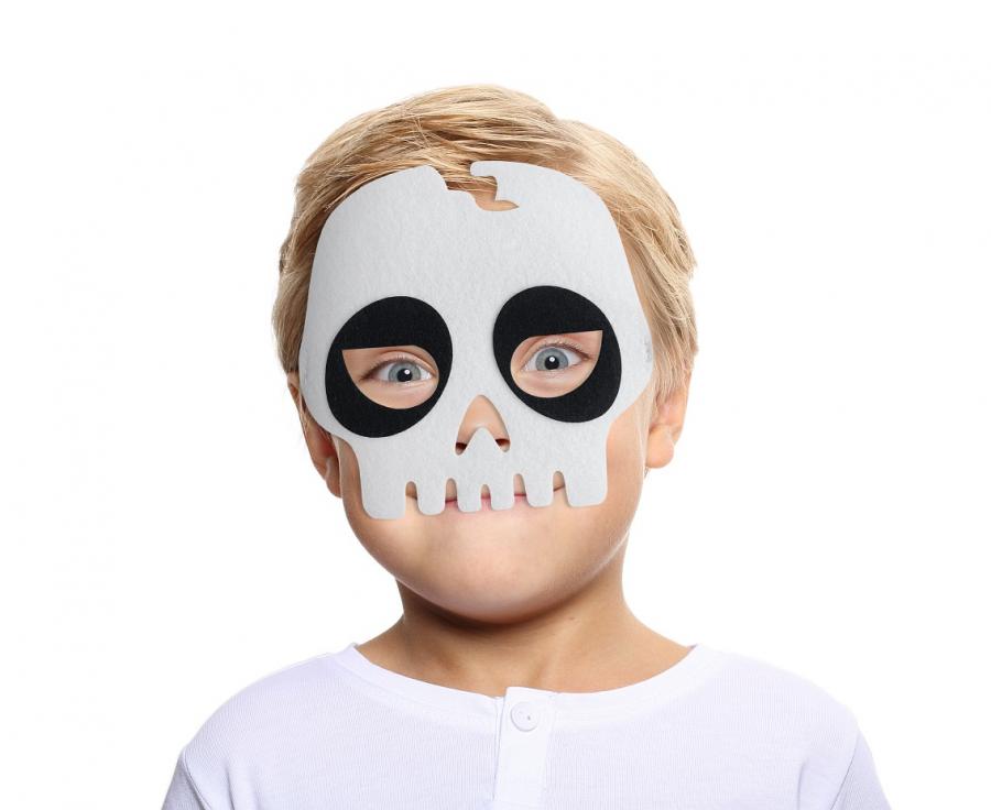 Bērns ar baltu filca skeleta masku sejā