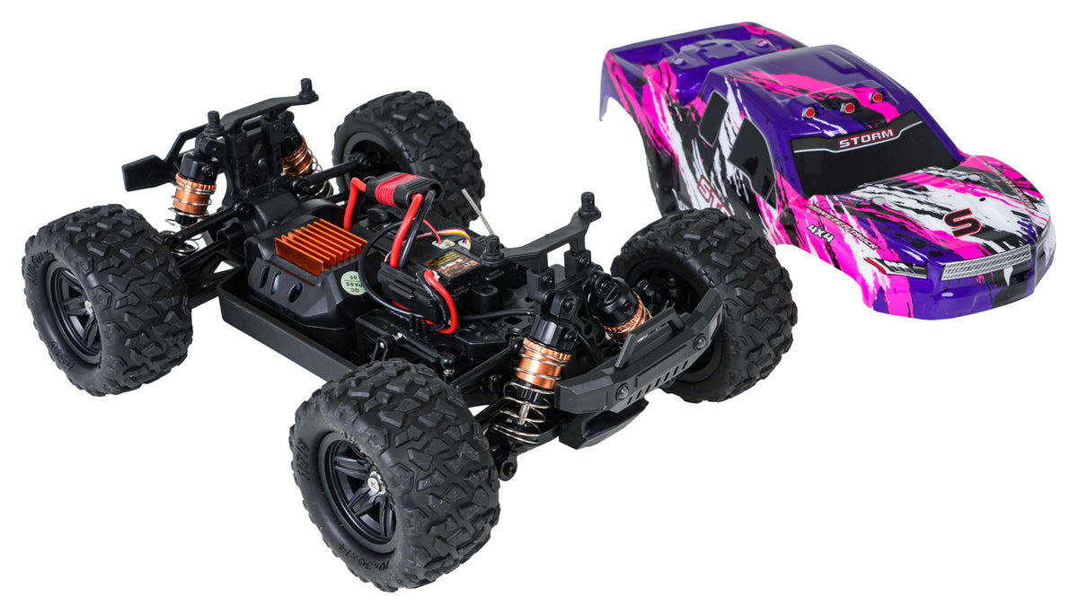 HOSPEED STORM V26 radiovadāms bezceļu monster truck auto mērogā 1:18 ar 4x4 pilnpiedziņu, atsegtu šasiju, redzamu elektroniku, piedziņas sistēmu un atsperu amortizatoriem, blakus noņemta violeti rozā virsbūve