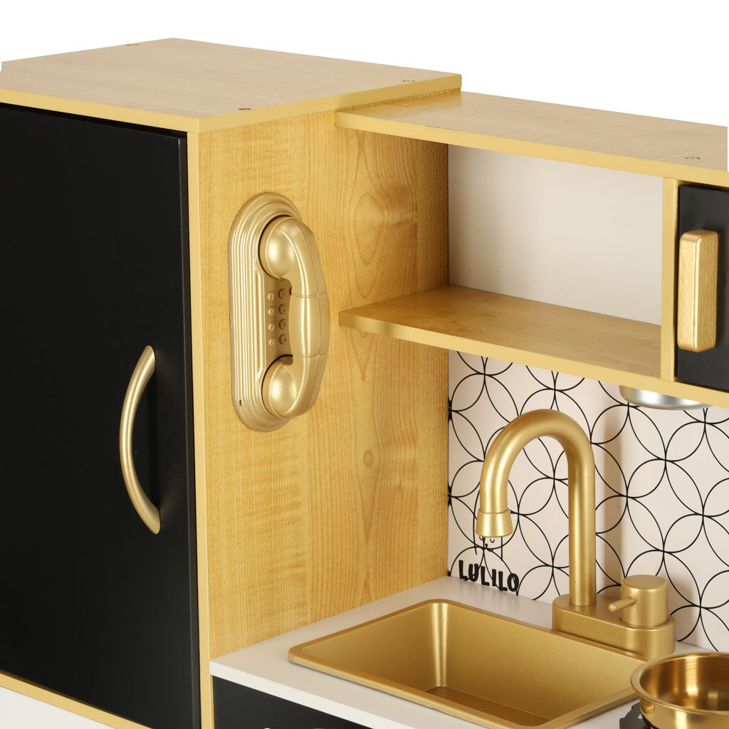 koka bērnu virtuve ar zelta izlietni un rotaļu telefonu pie sāna