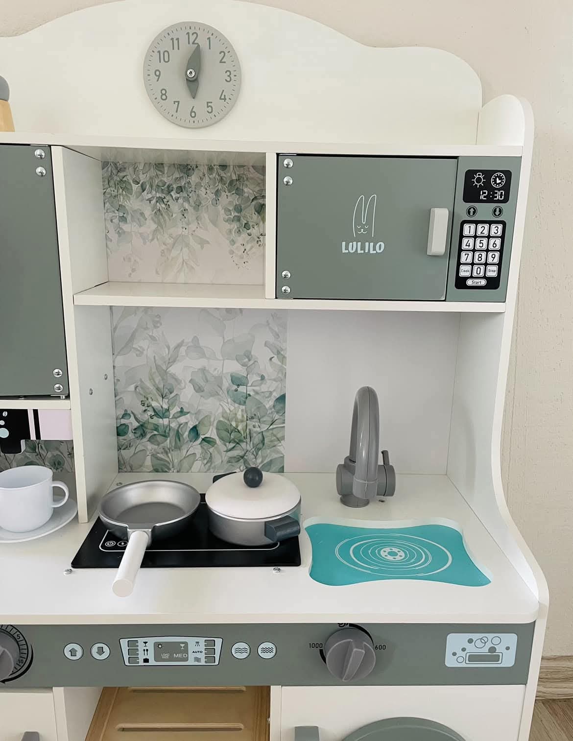 Koka rotaļu virtuves augšējā daļa ar plīti, izlietni, pannām un skapīšiem.