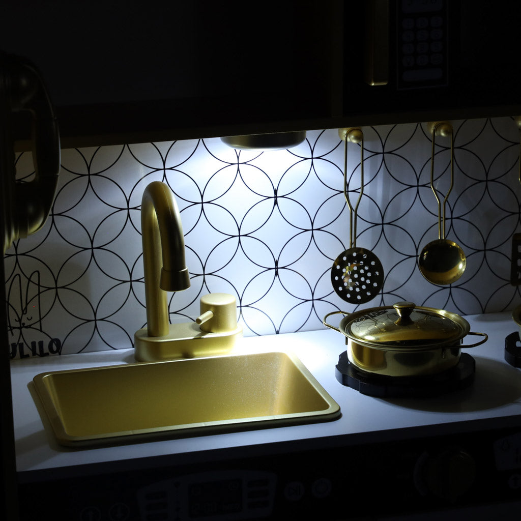 bērnu koka virtuves izlietne un plīts izgaismotā nakts režīmā