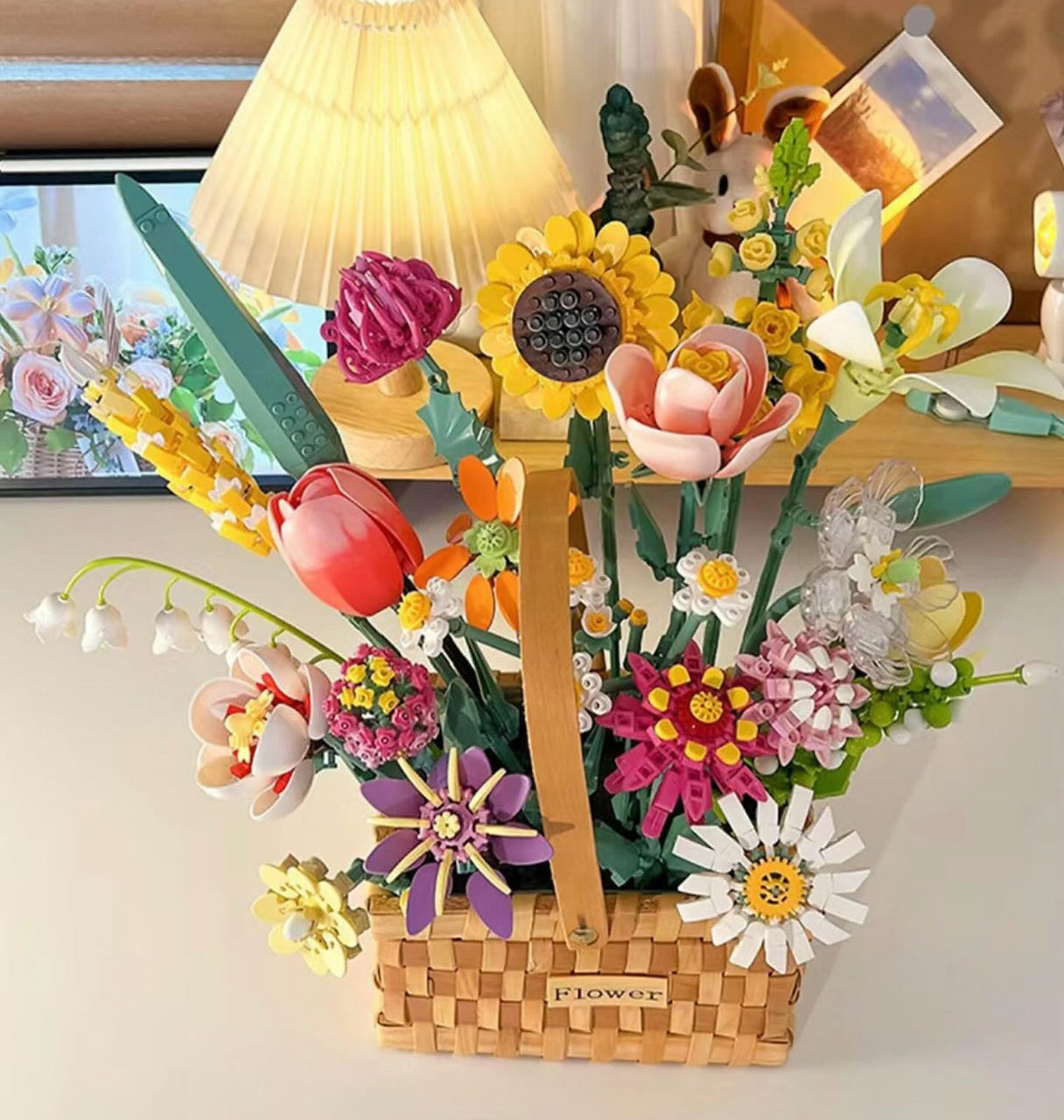 Konstruktoru ziedu kompozīcija dekoratīvā grozā uz galda interjerā