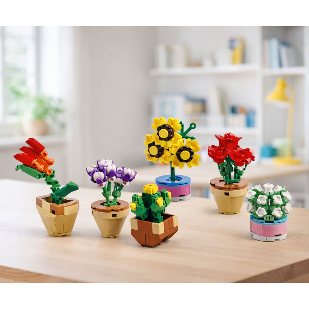 Konstruktoru ziedu un augu kompozīcijas podiņos uz galda interjerā