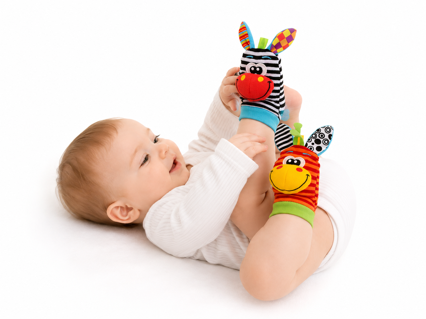 Mazulis spēlējas ar zebras grabulīšu zeķēm uz kājām