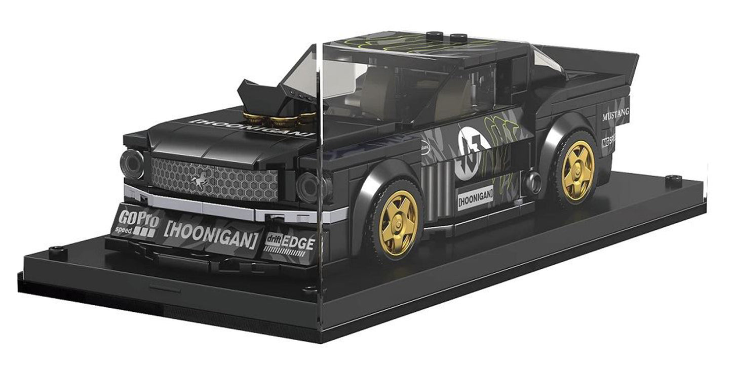 Melns sporta auto konstruktors uz melnas pamatnes ar caurspīdīgu aizsargstiklu un zelta diskiem