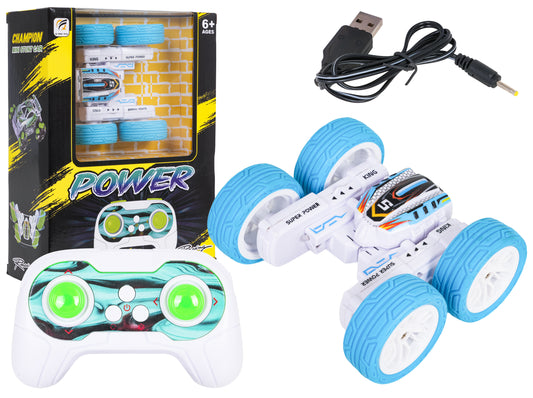 R C Power Stunt tālvadības kaskadieru auto ar pulti, uzlādes kabeli un zili baltu korpusu