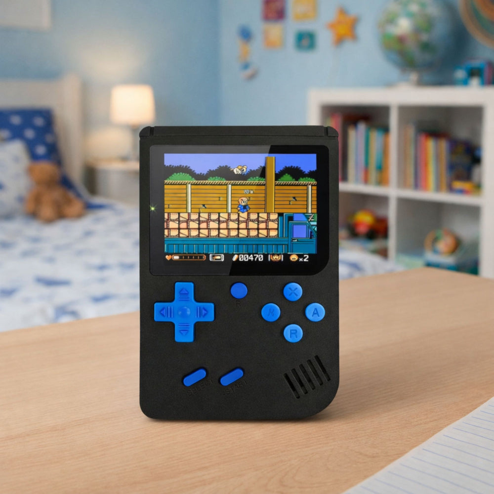 Melna retro spēļu konsole ar LCD ekrānu un zilām pogām novietota uz galda bērnistabā, ekrānā redzama spēle