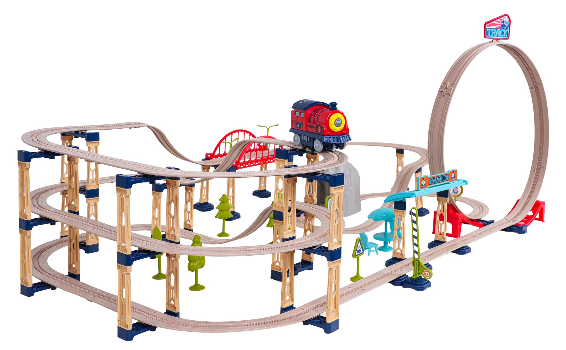 Liela daudzlīmeņu rotaļu dzelzceļa trase ar tiltiem, tuneli un 360° cilpu, kur pa augšējo sliedi brauc sarkans rotaļu vilciens.