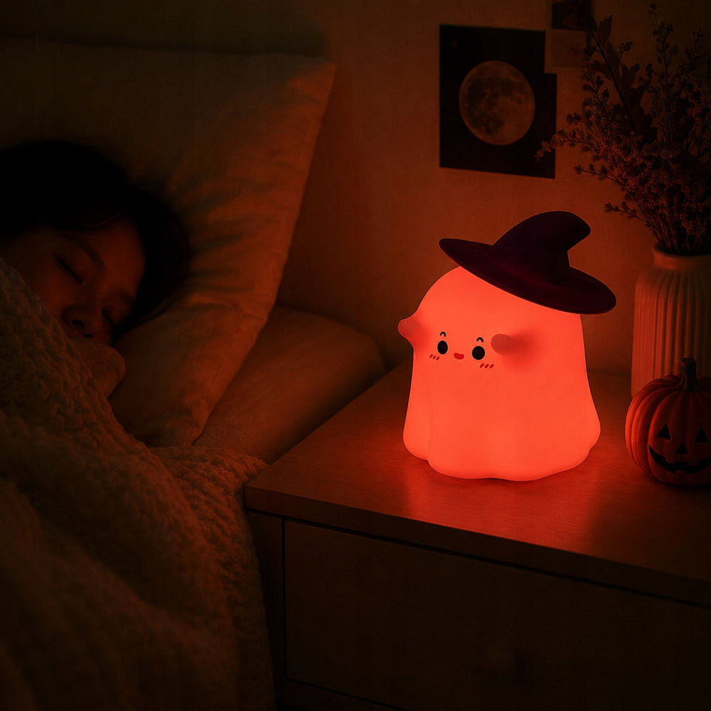 Silikona spoka LED RGB naktslampiņa sarkanā gaismā uz naktsgaldiņa blakus guļošam bērnam