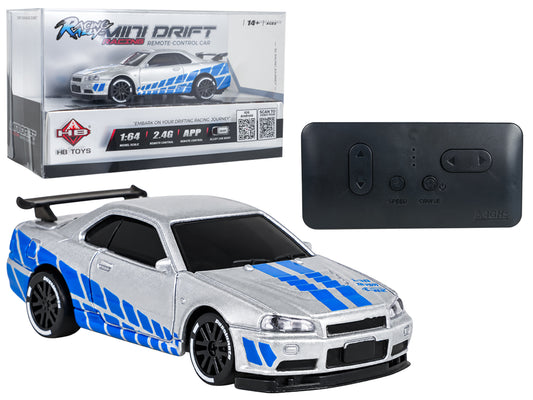 Sudrabota mini RC drifta automašīna 1:64 mērogā ar metāla virsbūvi, zilām sportiskām svītrām, melniem diskiem un aizmugurējo spoileri, komplektā 2,4 GHz tālvadības pults un oriģinālais HB Toys iepakojums, vadāma arī ar mobilo aplikāciju