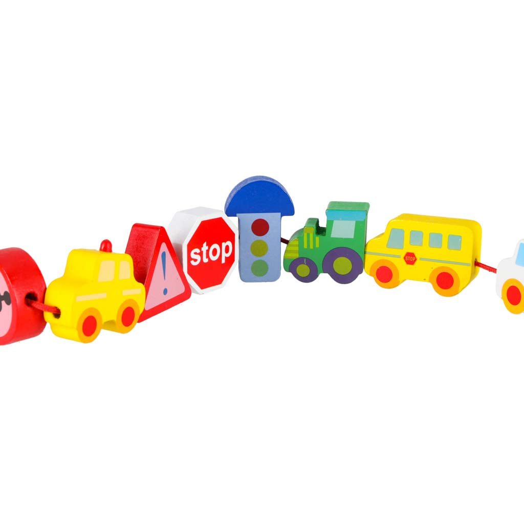 Uz aukliņas savērtas koka ceļa zīmes un transporta figūriņas tuvplānā