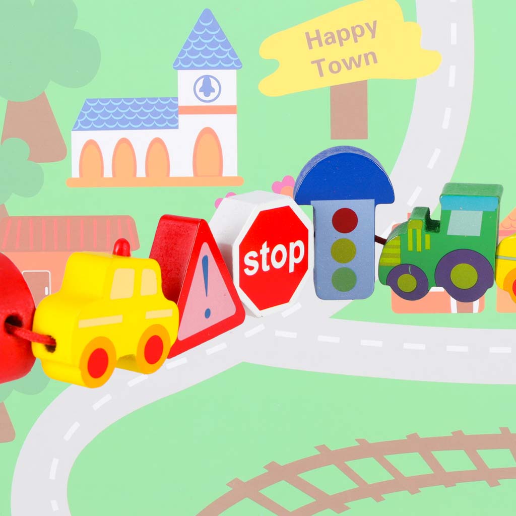 Uz aukliņas savērtas koka transporta un ceļa zīmju figūriņas uz pilsētas pamatnes tuvplānā