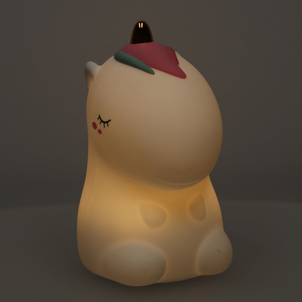 Iedegta vienradža silikona naktslampiņa siltā dzeltenā tonī.